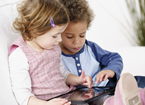 Two young children using a tablet