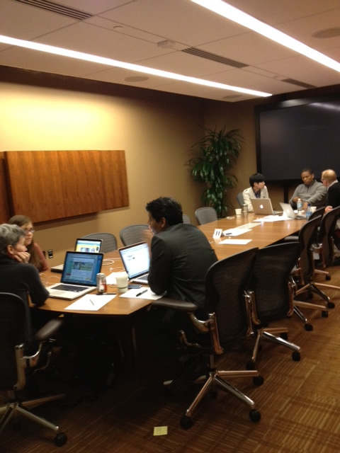 Two groups, working at different ends of a long conference table