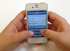 Hands typing message on iPhone