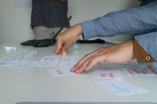 A person rearranges cards on a table.