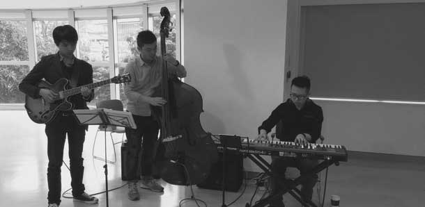 A trio of musicians playing guitar, bass and keyboard