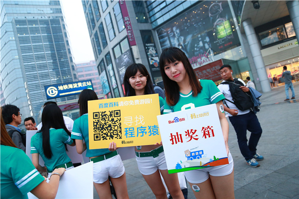 A group of women marketers stand holding signs promoting Baidu Baike.