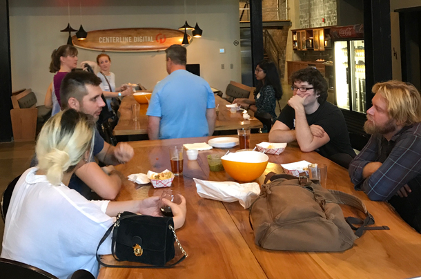 A photo of a group of members from Triangle UXPA discussing UX trends in a happy hour setting