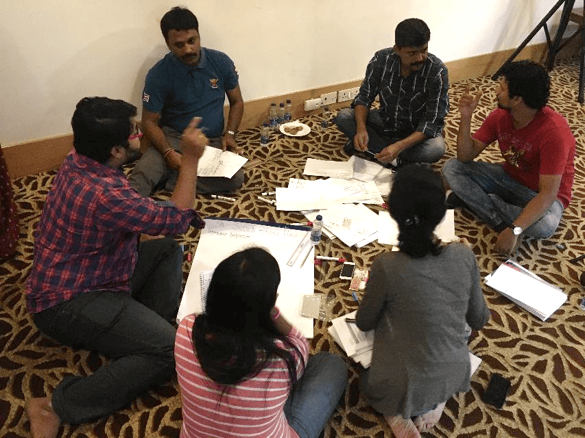 Photo of a group of people sitting in a circle in active discussion. 